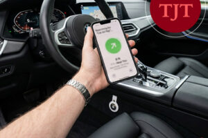 Driver checking a location-tracking app on a smartphone mounted near the steering wheel in New Jersey